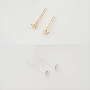 May include: Two gold and one silver nose rings with a star design. The nose rings are on a white background.
