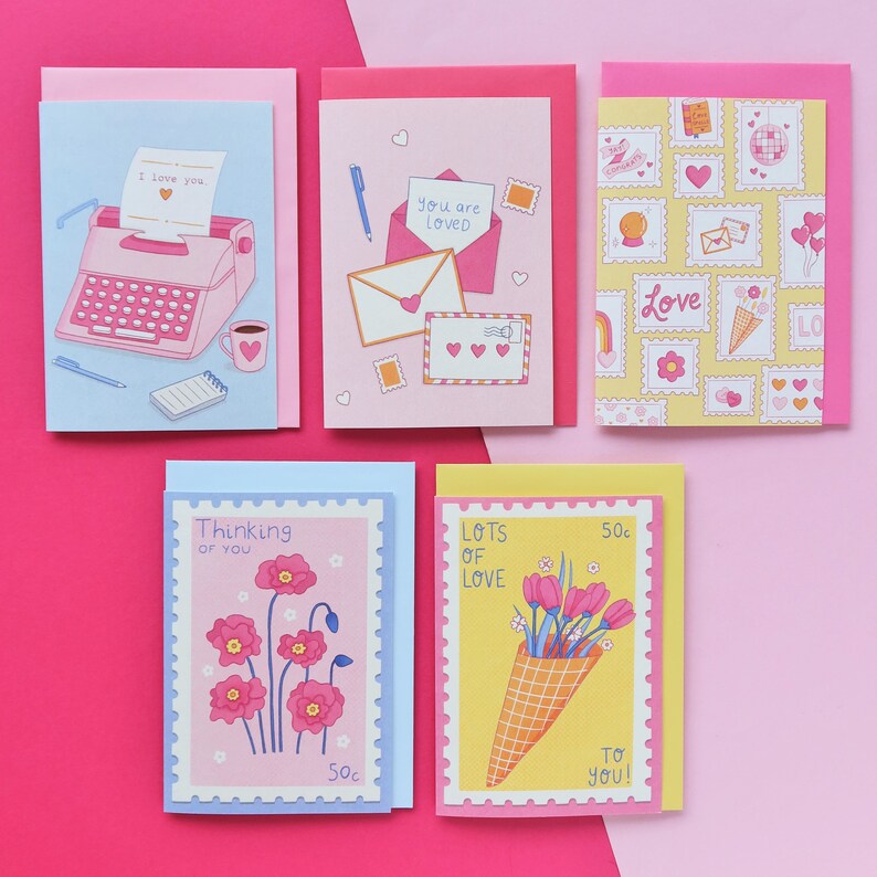 Pu&ograve; includere: Cinque biglietti d'auguri con diversi design. Le carte sono tutte rosa, blu e gialle con un bordo bianco. Le carte presentano illustrazioni di una macchina da scrivere, una lettera, fiori e un cono gelato. Le carte hanno il testo "Ti amo", "Sei amato", "Pensando a te", "Tanto amore" e "Amore".