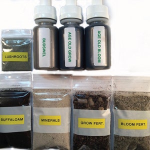 Pu&ograve; includere: Un set di forniture per il giardinaggio in sacchetti di plastica trasparenti, tra cui un piccolo sacchetto di polvere verde etichettato "LUSHROOTS", una bottiglia di liquido scuro etichettata "BUDSWEL", due bottiglie di liquido scuro etichettate "AGE OLD GROW" e "AGE OLD BLOOM", un sacchetto di terriccio marrone scuro etichettato "BUFFALOAM", un sacchetto di polvere marrone chiaro etichettato "MINERALS", un sacchetto di terriccio marrone scuro con piccole palline marroni etichettato "GROW FERT." e un sacchetto di terriccio marrone chiaro etichettato "BLOOM FERT."