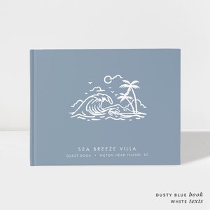 May include: A dusty blue guest book with a white illustration of a wave, palm trees, and a sun. The text "SEA BREEZE VILLA" and "GUEST BOOK - HILTON HEAD ISLAND, SC" is printed in white.