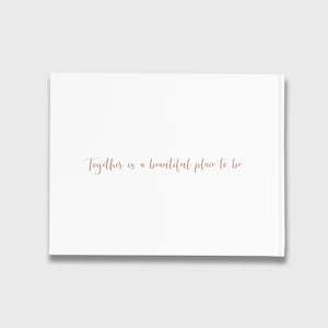 May include: White card with the text "Together is a beautiful place to be" written in cursive in a light brown color.