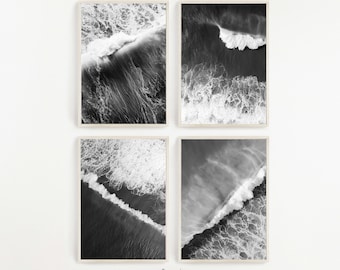 May include: Set of four black and white photographs of ocean waves crashing against the shore. The photos are framed in a simple white frame.