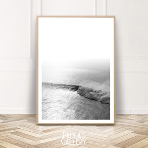 Könnte beinhalten: Ein Schwarzweißfoto einer großen Welle, die im Meer bricht. Die Welle bricht über einem felsigen Vorsprung und erzeugt einen Sprühnebel.