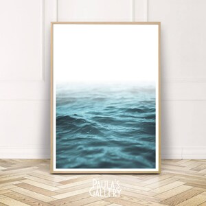 Może przedstawiać: Zdjęcie niebieskiego oceanu z falami. Woda ma jasnoniebieski kolor, a fale są małe i łagodne.