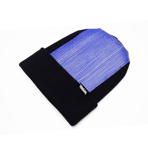 Puede incluir: Un gorro negro con un panel tejido azul en la parte superior. El gorro tiene un borde doblado y una pequeña etiqueta blanca con texto negro en la parte inferior derecha.