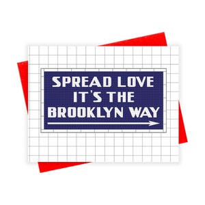 May include: A blue and white sign with the text "Spread Love It's The Brooklyn Way" and a white arrow pointing to the right.