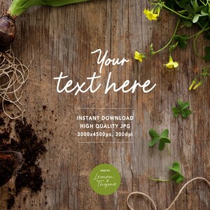 May include: A rustic wooden background with gardening elements. Includes a bulb with roots, a trowel, soil, twine, and sprigs of clover and yellow flowers. Text overlay reads "Your text here".