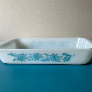 May include: White rectangular baking dish with a blue floral design. The dish is made of glass and has a smooth, glossy finish.