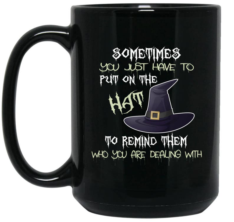 May include: Black coffee mug with a white design that says "Sometimes you just have to put on the hat to remind them who you are dealing with". The design also includes a black witch's hat.