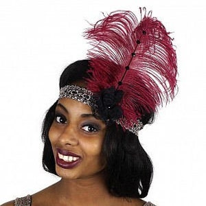 May include: A burgundy feather headband with a black beaded band and a black flower accent. The headband is worn by a person with short black hair.