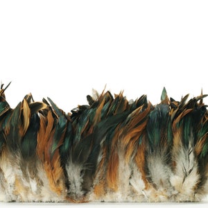 May include: A decorative item composed of a dense arrangement of feathers. The feathers display a gradient of colors, including dark green, brown, and tan, with a lighter, off-white base. The item is set against a plain white background.