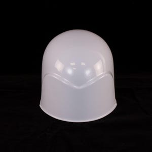 May include: A white plastic helmet with a rounded top and a curved visor. The helmet is smooth and glossy.