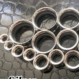 PAIR OF 9/16 INCH 14MM IRON CROSS INTERNAL THREADED PLUGS CARBON FIBER PAIR OF 9/16 INCH 14MM IRON CROSS INTERNAL THREADED PLUGS CARBON FIBER