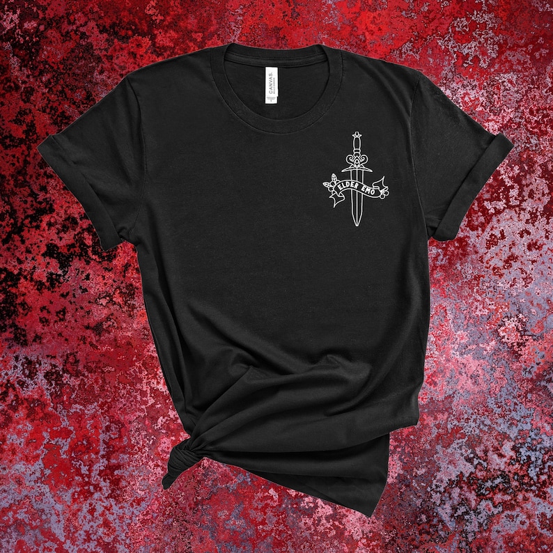 May include: Black t-shirt with a white graphic of a dagger with a banner that reads "Elder Bro".