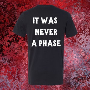 May include: Black t-shirt with white text that reads "It was never a phase."