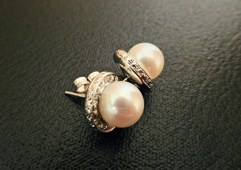 Fine cultured pearl earrings, Set in white gold, Diamond set rim Fine cultured pearl earrings, Set in white gold, Diamond set rim