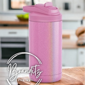 May include: A pink, glitter-covered water bottle with a flip-top lid. The bottle is cylindrical and sits on a wooden cutting board. The lid and top portion of the bottle are a solid pink, while the body has a glittery finish.