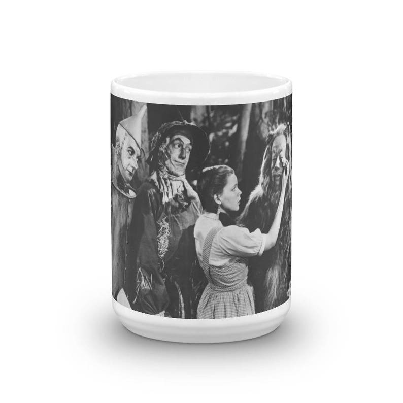 Puede incluir: Taza en blanco y negro con una escena de El mago de Oz. Dorothy aparece con el Espantap&aacute;jaros, el Hombre de Hojalata y el Le&oacute;n Cobarde.