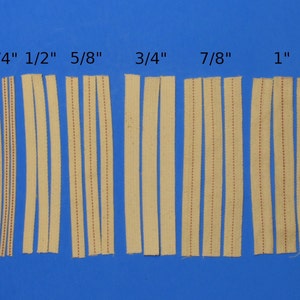 May include: Six strips of cotton lamp wicks in various sizes, from 1/4 inch to 1 inch, laid out on a blue background. The wicks are white with red stitching.