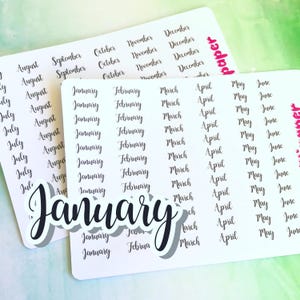 May include: A sheet of white sticker paper with black text. The sticker paper has rows of months of the year, including January, February, March, April, May, June, July, August, September, October, November, and December. The word "January" is written in large, bold, black letters at the bottom of the sheet.