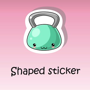 May include: A green cartoon kettlebell with a white outline and a cute face. The text "Shaped sticker" is below the kettlebell.