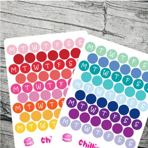 May include: Four sheets of colourful circle stickers with the days of the week labelled on each circle. The stickers are in shades of red, blue, green, and purple. The bottom of the sheet has a small cartoon macaron with the word "Chi" and "Chillin" written below.