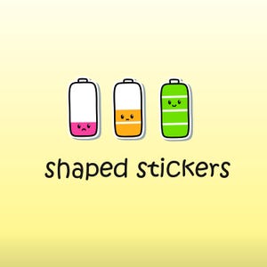 May include: Three cartoon battery shaped stickers with different facial expressions. The stickers are pink, orange, and green. The text "shaped stickers" is below the stickers.