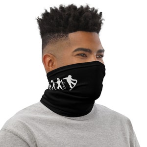 May include: A black neck gaiter featuring a white graphic depicting the evolution of snowboarding. The graphic shows a stick figure progressing from walking to skiing to snowboarding.