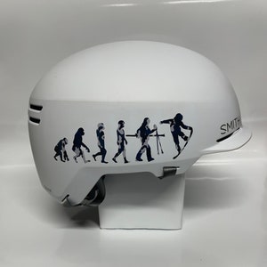 May include: White ski helmet with a black and white evolution graphic and the word "SMITH" on the side.