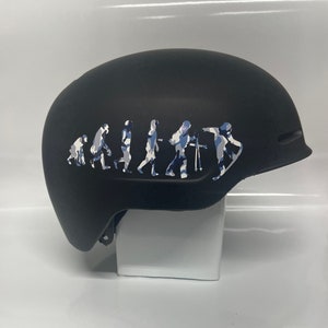 May include: Black ski helmet with a white and blue camouflage evolution of skiing graphic.