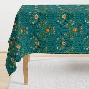 May include: Teal tablecloth with a floral pattern featuring orange, yellow, and pink flowers. The tablecloth has a repeating pattern of flowers and leaves.