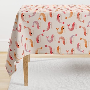 May include: A white tablecloth with a repeating pattern of pink and orange shrimp with hearts. The shrimp are stylized and have a watercolor effect.
