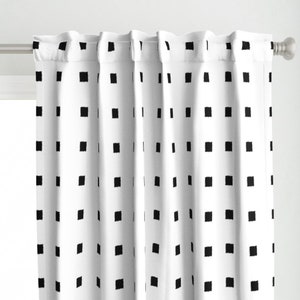 Puede incluir: Cortinas blancas con un patrón de cuadrados negros. Las cortinas están colgadas de una barra blanca.