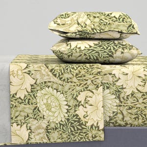 May include: A green and cream floral patterned bed sheet set with two matching pillowcases. The pattern features stylized flowers and leaves.