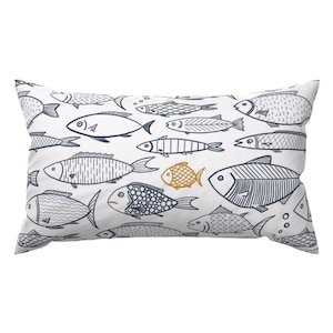 May include: A white pillow with a navy blue and yellow fish pattern. The pillow is decorated with a variety of fish, including some with stripes, dots, and scales.