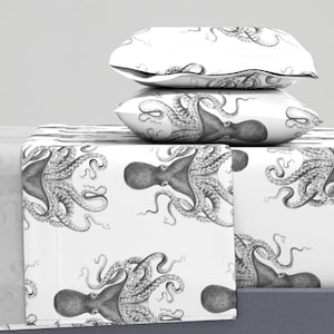 Op de afbeelding: Wit beddengoed met een zwart-witte octopusprint. De beddengoedset bevat een plat laken, een hoeslaken en twee kussenslopen.