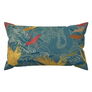 Puede incluir: Una almohada de tiro azul turquesa con un patrón de dragón y pájaros. El dragón es verde y los pájaros son rojos, amarillos y naranjas.
