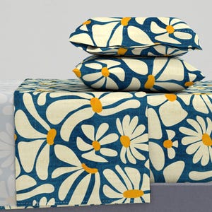 May include: A blue and white bedding set with a large daisy pattern. The set includes a fitted sheet, flat sheet, and two pillowcases.