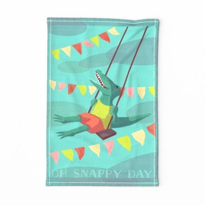 May include: A green alligator wearing a yellow shirt and red shorts is swinging on a swing set.  The background is a turquoise blue with yellow, pink, and orange pennant flags. The text "OH SNAPPY DAY" is at the bottom of the image.