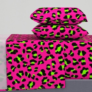 Könnte beinhalten: Bettwäsche-Set mit Leopardenmuster in Pink und Grün mit zwei passenden Kissenbezügen. Die Bettwäsche ist aus weichem, bequemem Stoff gefertigt und perfekt, um jedem Schlafzimmer einen Hauch von Spaß und Stil zu verleihen.