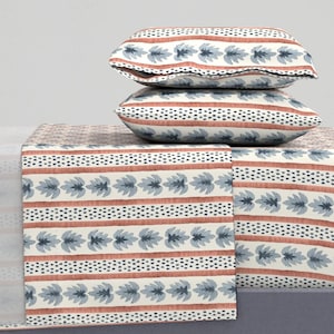 May include: A white and blue patterned bedding set with a red and white striped pattern. The set includes a flat sheet, fitted sheet, and two pillowcases.