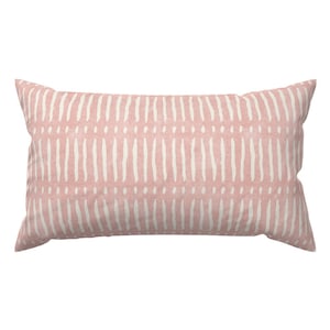 May include: A pink rectangular pillow with a white geometric pattern. The pattern is made up of vertical lines and small dots.