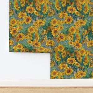 May include: A roll of wallpaper featuring a dense, repeating pattern of vibrant yellow sunflowers with dark brown centers and deep green leaves. The floral design is set against a muted, neutral gray background, creating a continuous botanical print.