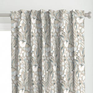 May include: A pair of beige curtains with a watercolor floral pattern featuring white flowers and blue leaves.