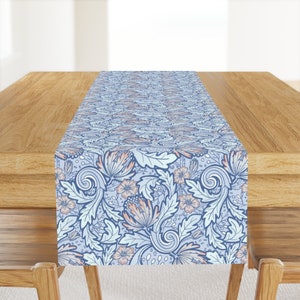 May include: A blue and pink floral table runner with a delicate pattern of leaves and flowers. The runner is made of a soft, durable fabric and is perfect for adding a touch of elegance to any dining table.