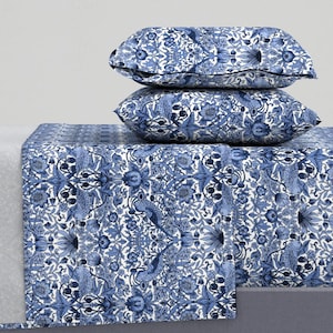 May include: A white and blue patterned bedding set with a floral and bird design. The set includes a flat sheet, fitted sheet, and two pillowcases.