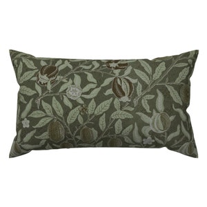 May include: A green rectangular pillow with a floral pattern featuring brown pomegranates and white flowers.