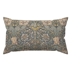 May include: A rectangular throw pillow with a floral pattern in shades of green, yellow, and white on a blue background. The pattern features stylized flowers, leaves, and vines.