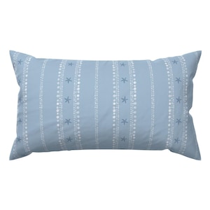 May include: A rectangular pillow with a light blue background. The pillow features vertical stripes of white dots and small blue starfish. The pillow is designed for decorative use.