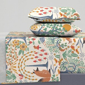 May include: Two decorative pillows and a table runner with a whimsical forest pattern. The pillows are stacked, showcasing a cream background with red, blue, and yellow floral and animal designs. The table runner features a similar design.